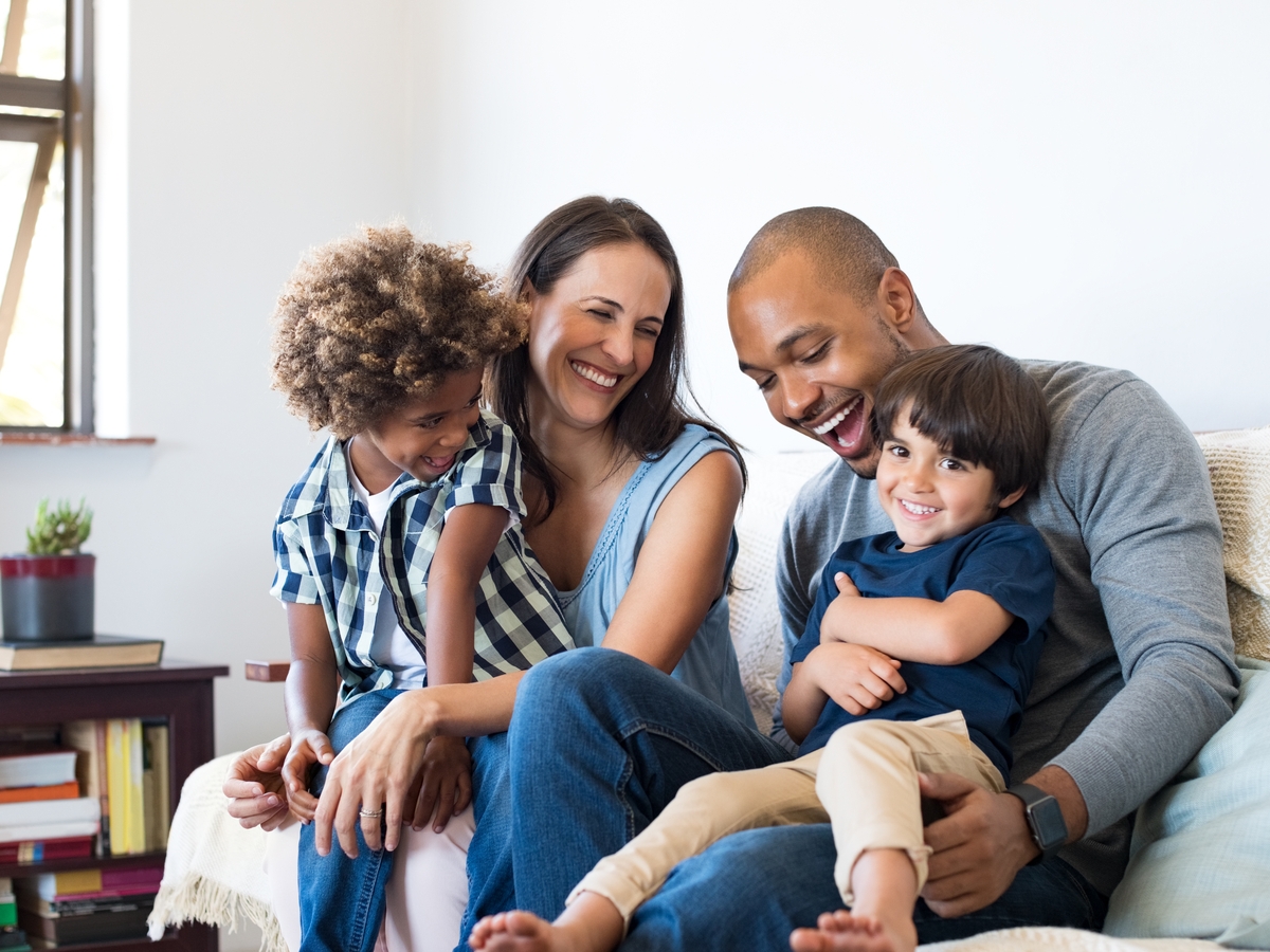 Happy Family Sitting On The Couch With Children