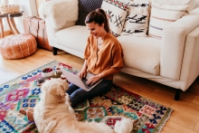 woman and her dog at home together on living room floor