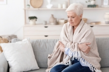 woman cold under a blanket at home