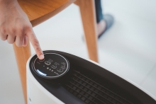 person turning on air purifier in home close up