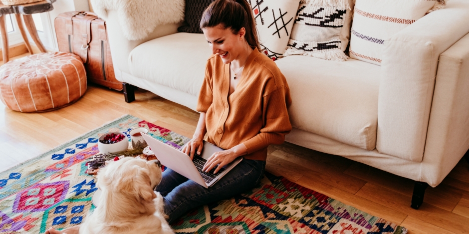 woman and her dog at home together on living room floor