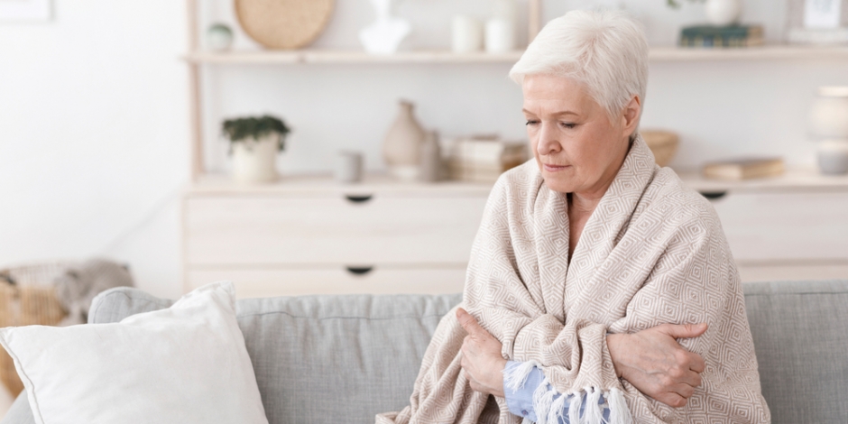 woman cold under a blanket at home